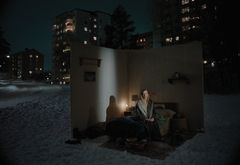 Kvinna i öppet rum under nattetid i vintermiljö.