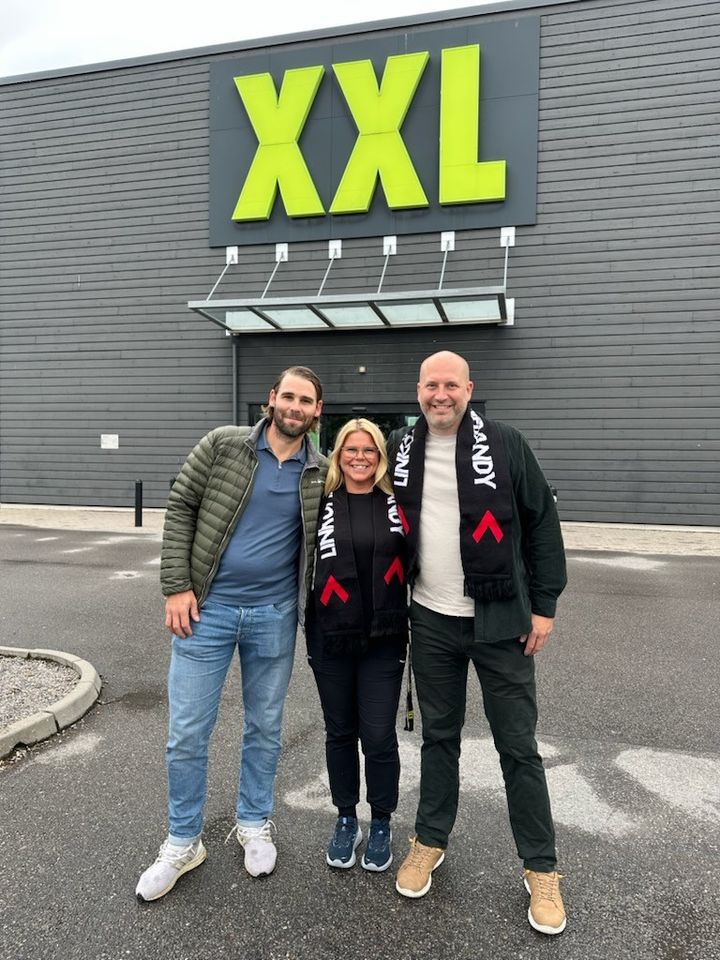 Tre människor står framför en XXL-butik.
