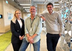 En kvinna och två män står på ett kontor