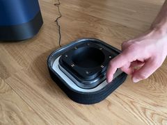 En hand pekar mot en öppen lusfälla med klister längst ner.