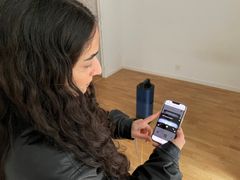 Kvinna använder en app på sin smartphone för att följa utvecklingsstadier av fångade löss.