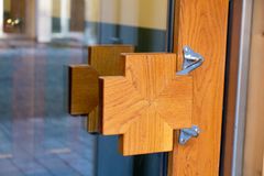 Ett trähandtag i korsform på en dörr i Stockholmshems plusenergihus i Norra Djurgårdsstaden.