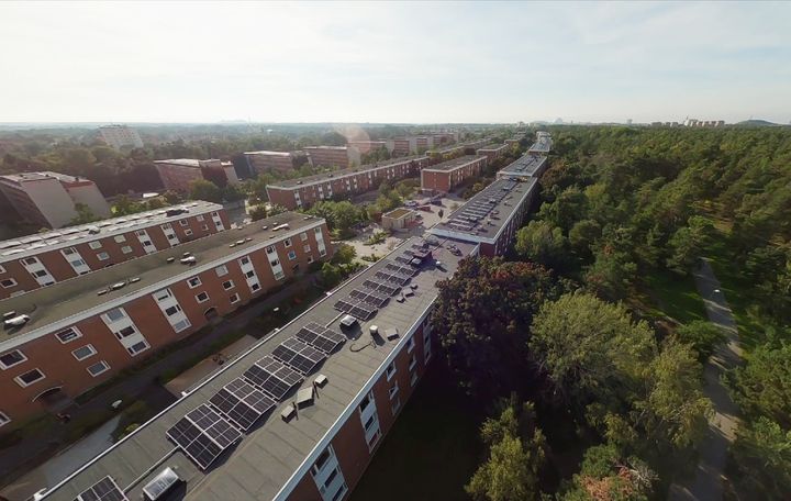 Alt text: Flygfoto över solcellsanläggning på flera tak i Bagarmossen.