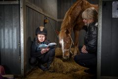 Läsläxan gör Molly bäst i stallet. Här med Champis och mamma Maria. Foto: Susanne Walström