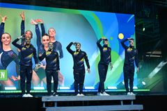 Det svenska EM-laget går in på en upphöjd plattform, klädda i tävlingsdräkter.