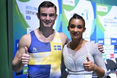 Två gymnaster i tävlingsdräkter står bredvid varandra och ger tummen upp.