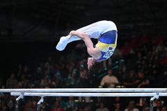 En gymnast utför en övning på parallellbarren.