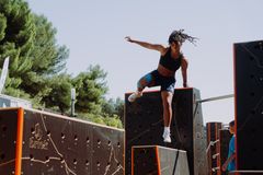 En kvinna hoppar över en hinderbana utomhus.