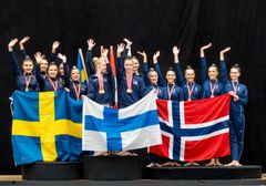 Framgångsrika gymnaster står på prispallen med svenska, finska och norska flaggor samt silvermedaljer runt halsen.