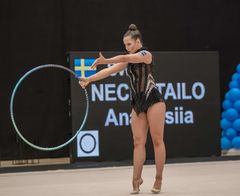 En gymnast utför ett rytmiskt övningsnummer med en ring.
