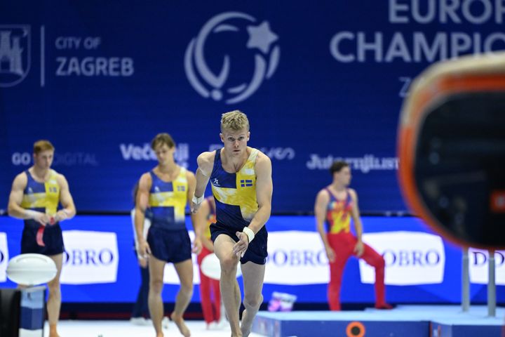 Gymnaster i tävlingsdräkter förbereder sig inför ett evenemang på Europeiska mästerskapen.
