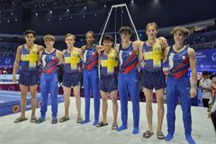 Bild på det svenska juniorlaget och laget från Frankrike i gymnastikställningar vid en tävling.