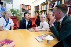 Sex personer, varav fem vuxna sitter och samtalar runt ett bord. En är läkarklädd.