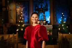 Kvinna ler stort rakt in i kameran.