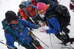 Personer som tittar på en karta i snöväder.