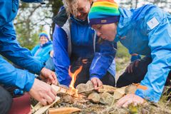 Grupp i naturen som tänder en eld.