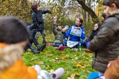 Barn och pedagog som har lektion utomhus.