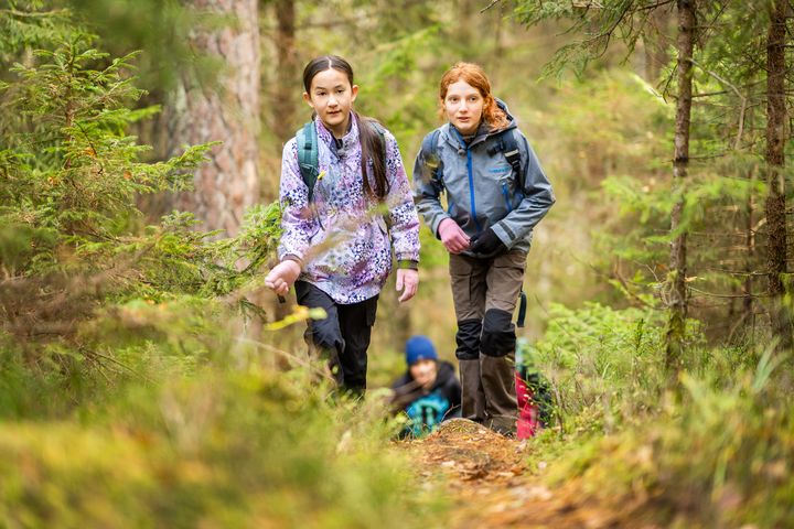 Två ungdomar som går på en skogsstig