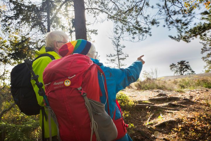 Två personer med vandringsryggsäckar i skogen.