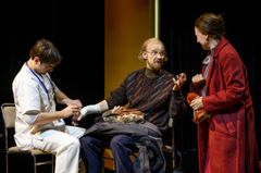 Tre personer agerar i en teaterscen.