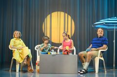 Fyra personer sitter på en scen med sommartema.