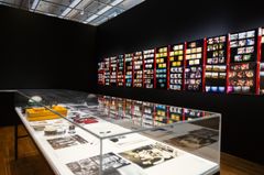 Fotografi av en utställning med bildväggar och en monter med foton och negativ.