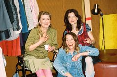 Marie Richardson, Elisabet Carlsson och Louise Peterhoff sitter och ler i en avslappnad miljö med kläder hängande i bakgrunden.