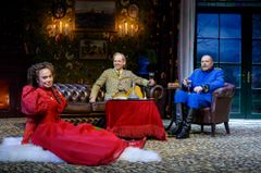 Lena Olin, Simon Reithner och Peter Andersson sitter i ett vardagsrum med färgglada kläder.