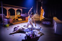En scen från teaterföreställningen "Medeas barn". Skådespelare i dramatiskt ljus på scenen.