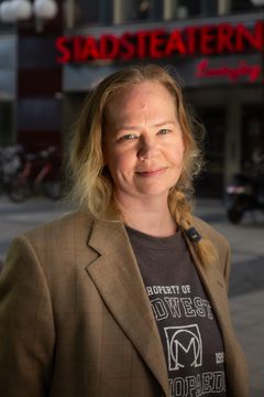 En person står framför en byggnad med texten "Stadsteatern".