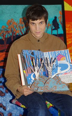 Bild på en person som håller en pop-up-bok med färgglada illustrationer.