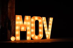 Upplysta bokstäver som bildar ordet ".MOV" mot en mörk bakgrund.