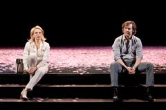 Helena Bergström och Magnus Krepper i en teaterscen med rosa blomblad på golvet.