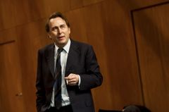 Philip Zandén i kostym står på scenen och talar.