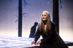 Ann Petrén  på en teaterscen med träd i bakgrunden.