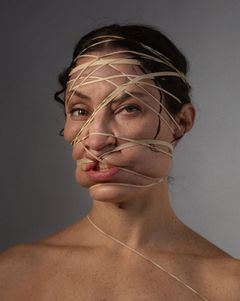 Kvinna med ansiktet åtspänt med gummiband.