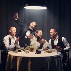 Fyra glada personer vid ett bord.