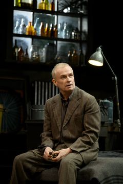 En skådespelare som sitter på sängen och tittar uppåt