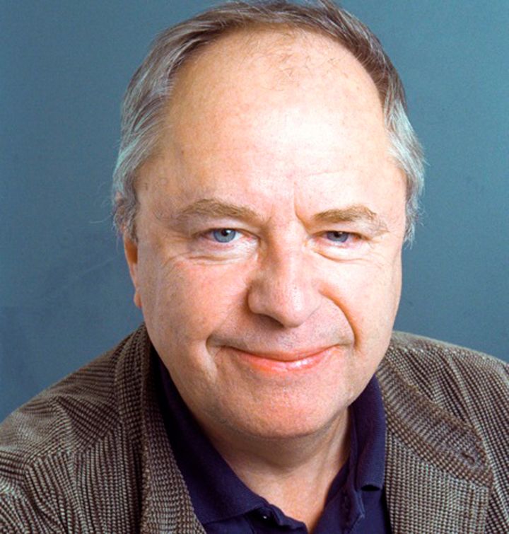 Porträtt av Helge Skoog mot en blå bakgrund.