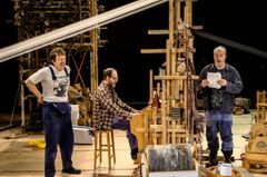 Tre personer på en teaterscen med rekvisita för uppsättningen "Män som väver".