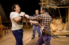 Tre personer på en scen, varav två uppträder en boxningsscen.