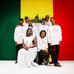 Grupp av personer framför en färgglad bakgrund.