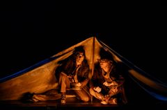 Två personer under en tältduk.