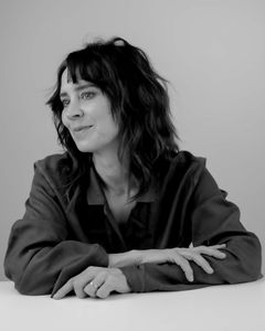 Frida Fjellman i svartvitt, sittande vid ett bord och tittar åt sidan.