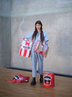 Sanne Lovén Rolén i blå kläder håller i stora textilverk av matprodukter.