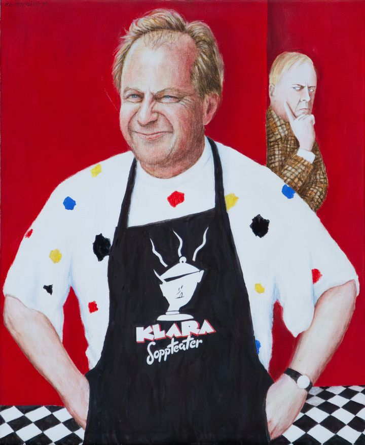 Porträttmålning i olja av en leende Helge Skoog i vit t-shirt med färgglada detaljer och svart förkläde som det står Klara Soppteater på. Han står framför en röd ridå och i en öppning tittar Ture Sventon fram.