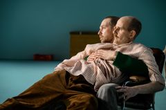 Bild på två personer som sitter tillsammans i en stol.