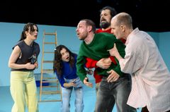 Fem skådespelare spelar en känslosam scen med en stege i bakgrunden.