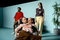 Fyra skådespelare i en fåtölj och på en trappa.