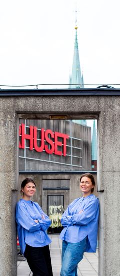 Två personer står leende framför Kulturhuset Stadsteatern.